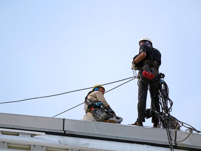 Man on top of structure wearing safety gear