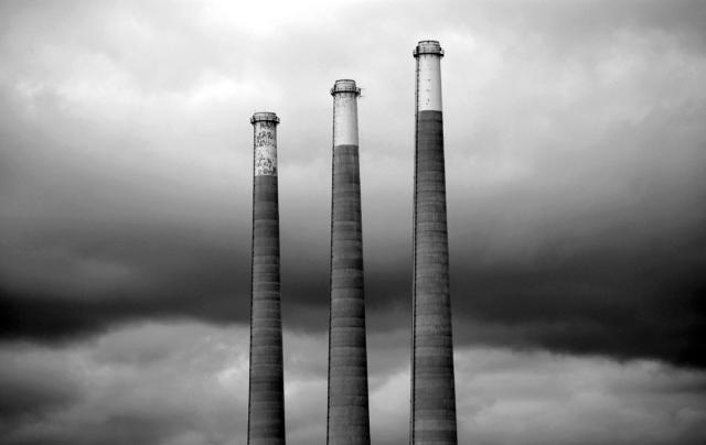 Three factory stacks rising into sky