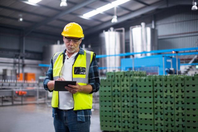 male-factory-worker-maintaining-record-on-clipboard