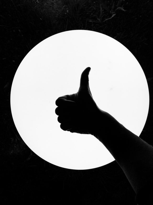 hand-giving-a-thumbs-up-in-front-of-a-circular-light