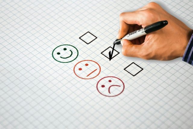 hand-writing-a-checkmark-on-a-feedback-survey