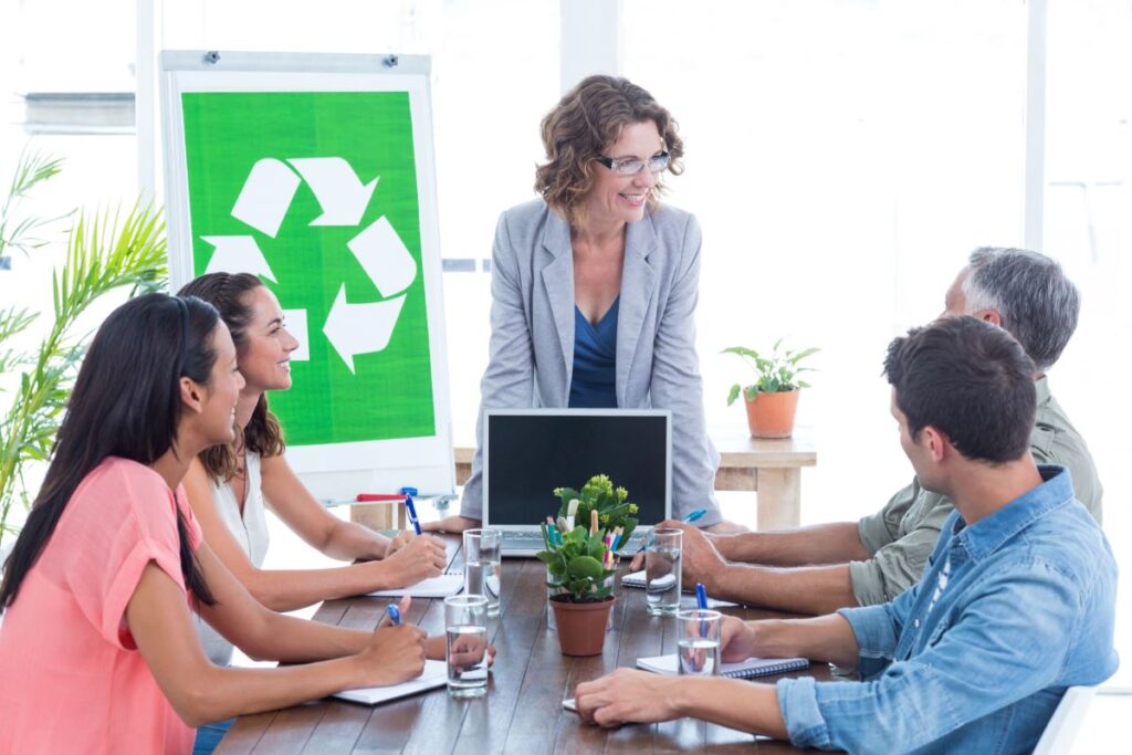 people-around-conference-room-table-with-recycle-symbol-displayed-on-a-flipchart
